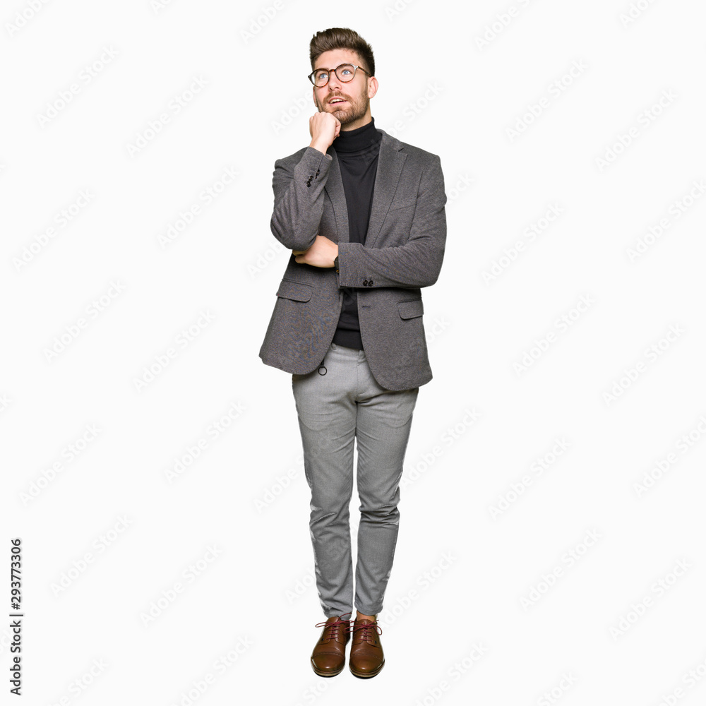 Young handsome business man wearing glasses with hand on chin thinking about question, pensive expression. Smiling with thoughtful face. Doubt concept. Young handsome business man wearing glasses with hand on chin thinking about question, pensive expression. Smiling with thoughtful face. Doubt concept.