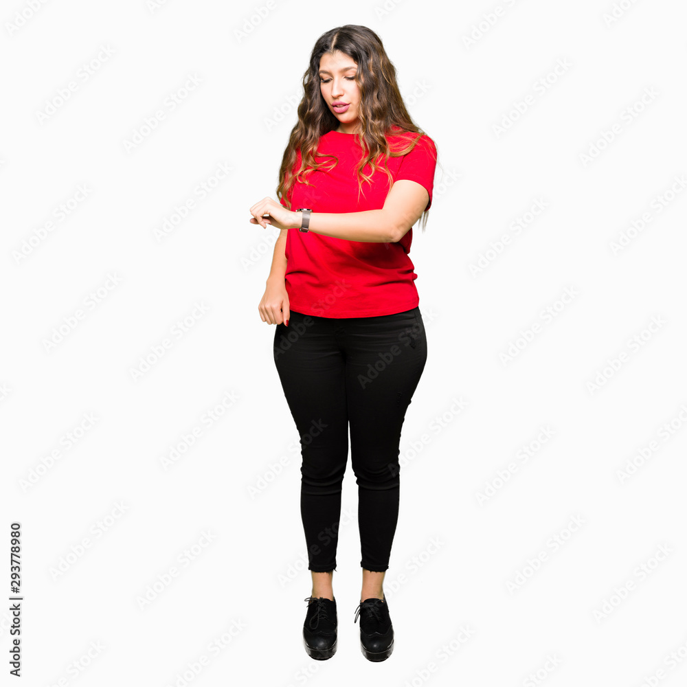 Young beautiful woman wearing casual t-shirt Checking the time on wrist watch, relaxed and confident Young beautiful woman wearing casual t-shirt Checking the time on wrist watch, relaxed and confident