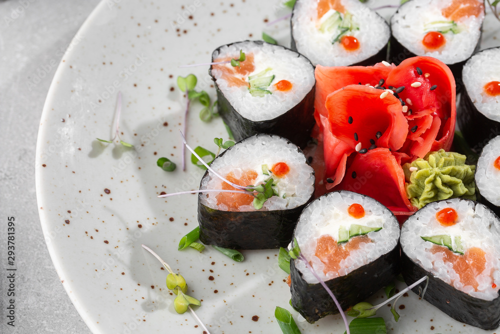 Maki rolls with salmon, cucumber, caviar and cheese. Fresh hosomaki pieces with rice and nori. Closeup of delicious japanese food. Sushi menu. Top view horizontal photo on white background. Maki rolls with salmon, cucumber, caviar and cheese. Fresh hosomaki pieces with rice and nori. Closeup of delicious japanese food. Sushi menu. Top view horizontal photo on white background.