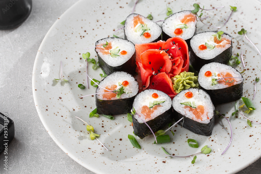 Maki rolls with salmon, cucumber, caviar and cheese. Fresh hosomaki pieces with rice and nori. Closeup of delicious japanese food. Sushi menu. Top view horizontal photo on white background. Maki rolls with salmon, cucumber, caviar and cheese. Fresh hosomaki pieces with rice and nori. Closeup of delicious japanese food. Sushi menu. Top view horizontal photo on white background.