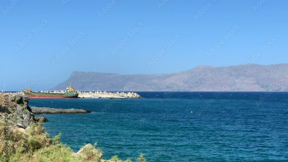 Big green and red ship staying at harbor entrance. Huge tanker in the sea at summer. Big green and red ship staying at harbor entrance. Huge tanker in the sea at summer.