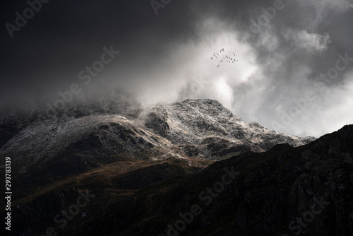 Fotografia Stunning moody dramatic Winter landscape image of snowcapped Tryfan mountain in
