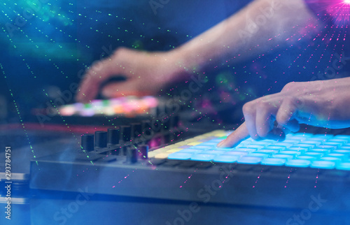 Hand mixing music on midi controller with party club colors around