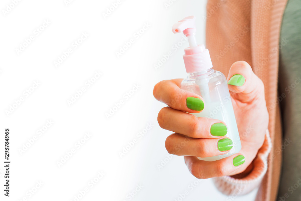 Woman's hand holding pink lotion doser Woman's hand holding pink lotion doser