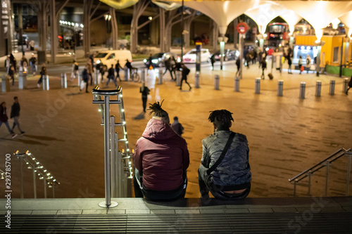 Obraz na płótnie Two boys seats on the floow of stratford station of London Uk, and looking towards the stratfor shopping center w salonie
