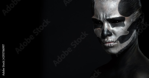 Halloween. Woman in day of the dead mask skull face art. Halloween face art on black background. Halloween make up.