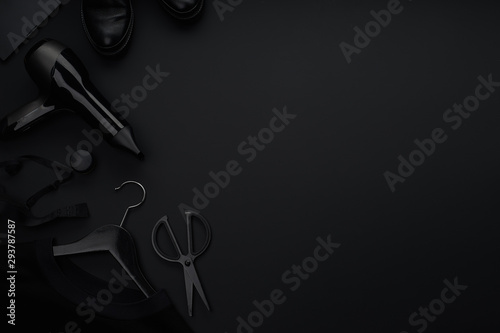 Black monochromatic flatlay on black background. Clothes, accessories and beauty equipment. Black friday sale concept. Copy space