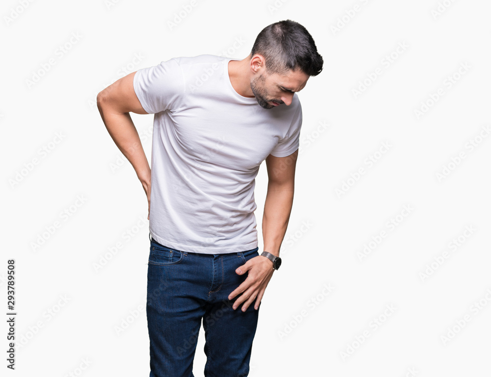 Handsome man wearing white t-shirt over white isolated background Suffering of backache, touching back with hand, muscular pain Handsome man wearing white t-shirt over white isolated background Suffering of backache, touching back with hand, muscular pain