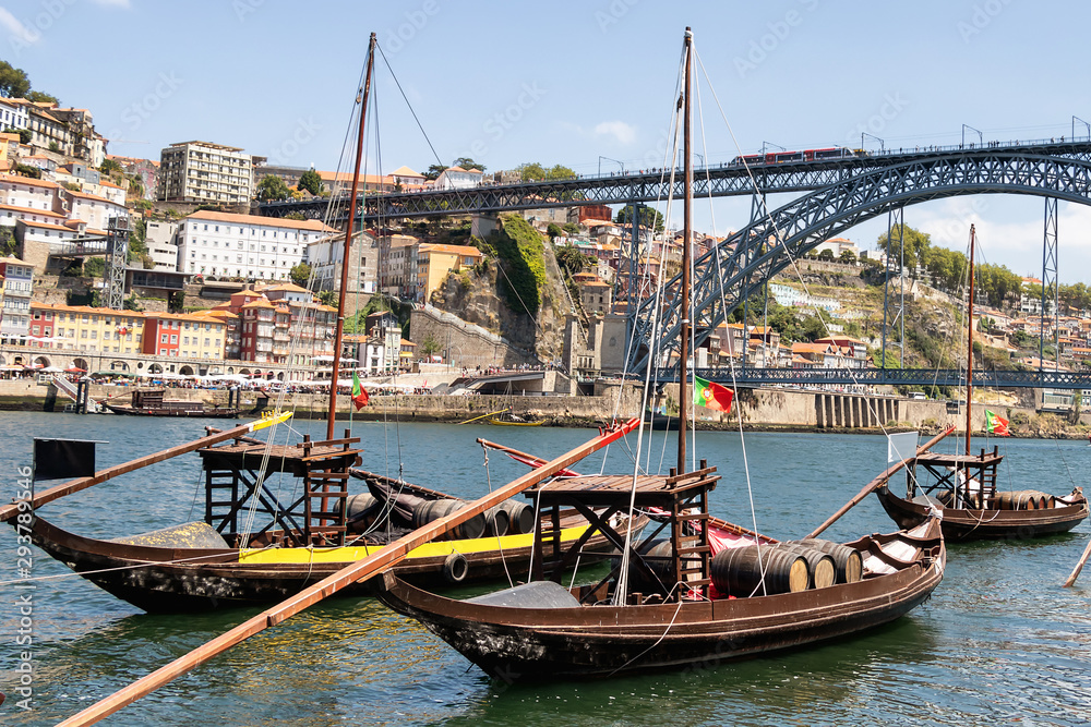Porto and old traditional boats with wine barrels in Portugal with Dom Luis I Bridge in the background