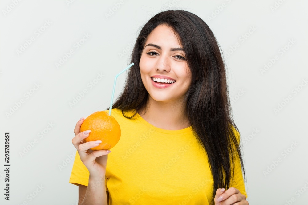 Young hispanic woman drinking an orange juice with a straw Young hispanic woman drinking an orange juice with a straw
