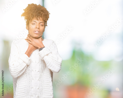 Beautiful young african american woman wearing winter sweater over isolated background shouting and suffocate because painful strangle. Health problem. Asphyxiate and suicide concept. © Krakenimages.com