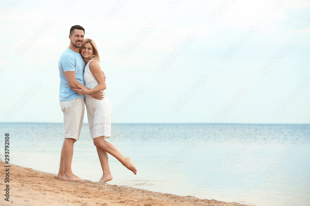 Happy romantic couple spending time together on beach, space for text Happy romantic couple spending time together on beach, space for text