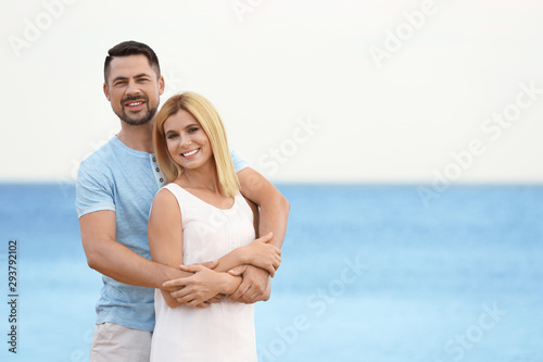 Happy romantic couple spending time together on beach, space for text © New Africa