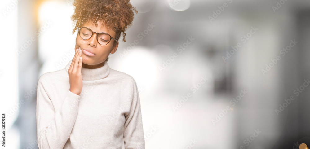 Obraz premium Beautiful young african american woman wearing glasses over isolated background touching mouth with hand with painful expression because of toothache or dental illness on teeth. Dentist concept.