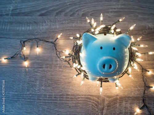 Blue piggy bank with Christmas string lights on happy December festival, Enjoy savings for spending money on the holiday's concept. photo