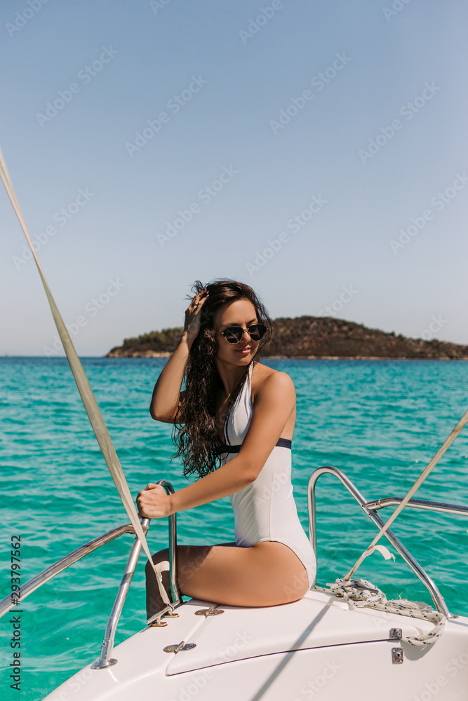 beautiful girl with dark hair in luxurious bikini relaxing on yacht in the  sea. Woman on board of boat in Greece foto de Stock | Adobe Stock