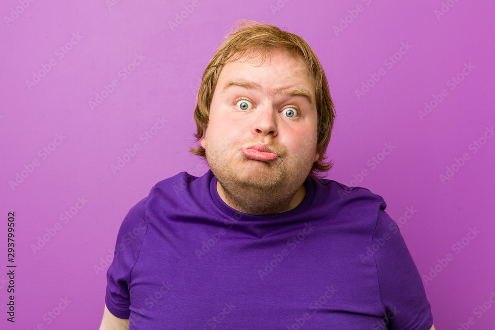 Young authentic redhead fat man shrugs shoulders and open eyes confused. Young authentic redhead fat man shrugs shoulders and open eyes confused.