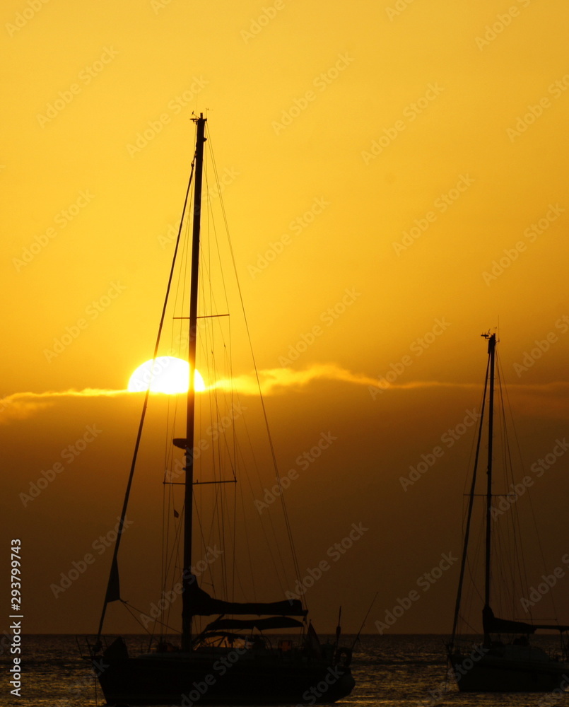 sunset behind boats