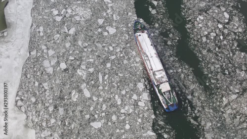 Winter landscape from a height. Barge on the river among the ice floes
