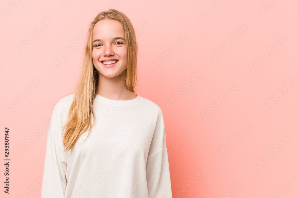 Caucasian teenager standing against a pink background Caucasian teenager standing against a pink background