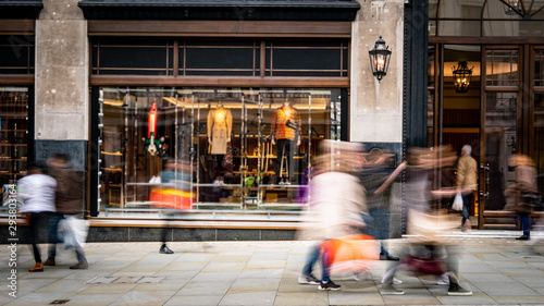 Motion blurred people walking on shopping street photo