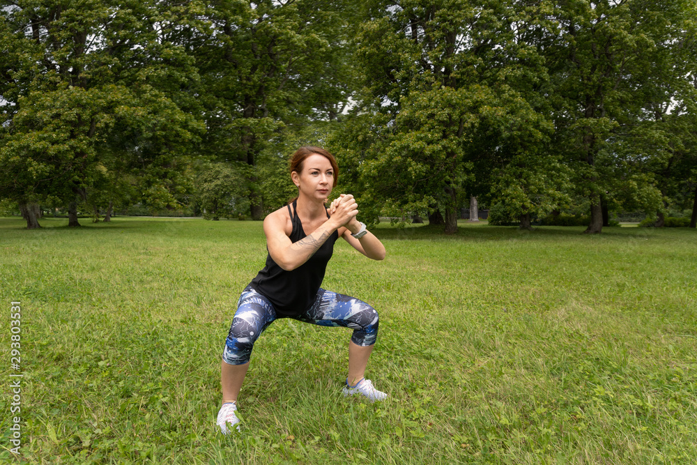 sport woman wearing exercise suit doing stretching fitness exercise in city park at green grass. sport woman wearing exercise suit doing stretching fitness exercise in city park at green grass.