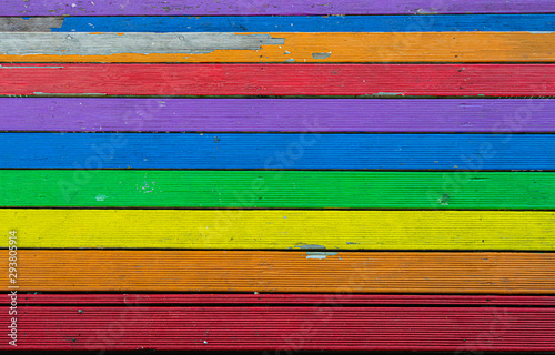 Raunbow coloured wooden planks of a floor seen from above.