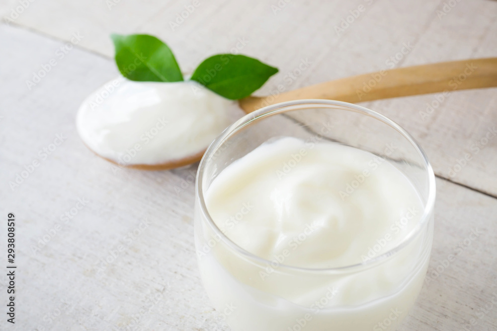 Yogurt cup and spoon on white wood background. Yogurt cup and spoon on white wood background.
