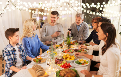 celebration, holidays and people concept - happy family having dinner party, drinking red wine and toasting at home