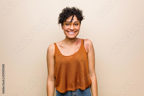 Young african american woman with skin birth mark happy, smiling and cheerful.