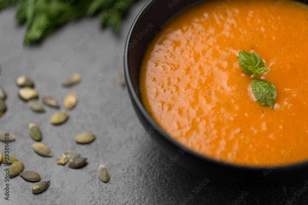 food, new nordic cuisine, culinary and cooking concept - close up of vegetable pumpkin cream soup in bowl on stone table food, new nordic cuisine, culinary and cooking concept - close up of vegetable pumpkin cream soup in bowl on stone table
