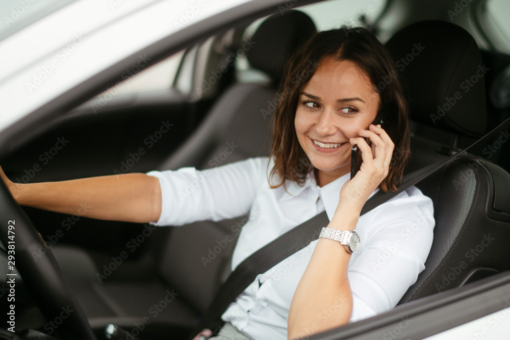 Young businesswoman in car using phone