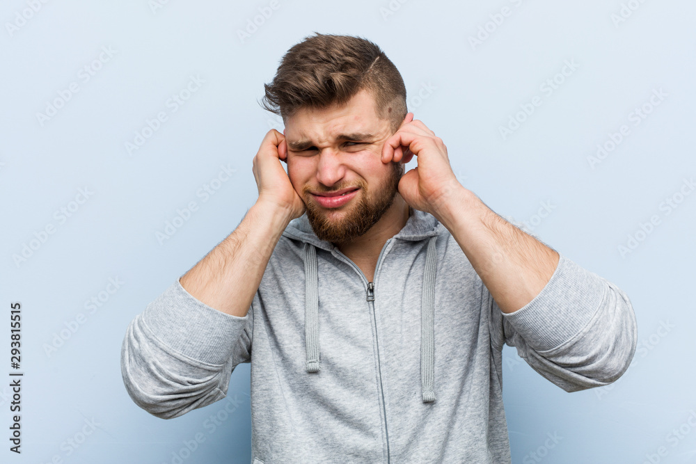 Young handsome fitness man covering ears with his hands. Young handsome fitness man covering ears with his hands.