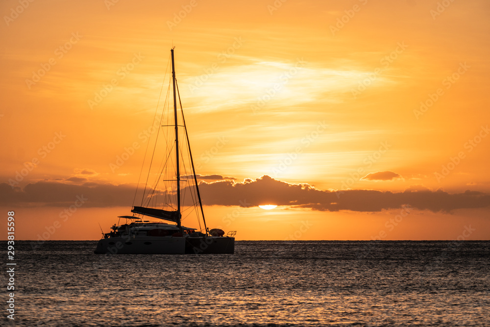 Sunset over two catamaran sailboat off the Yasawa island in Fiji