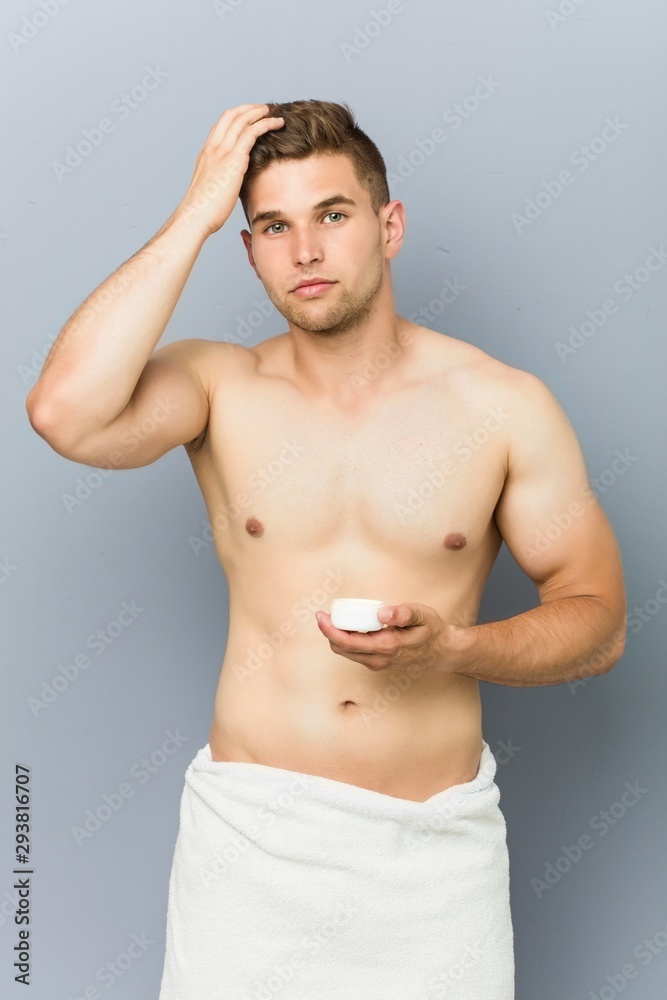 Young handsome man using hair wax