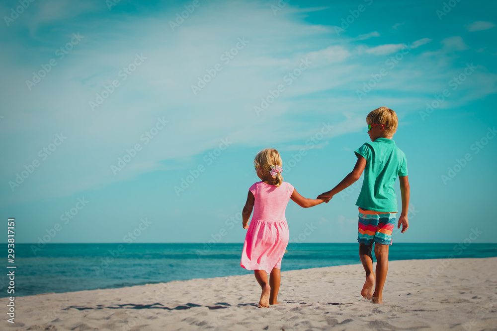 little boy and girl walking on beach