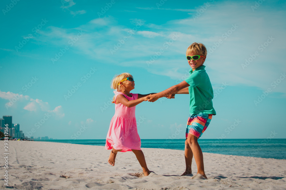 happy boy and girl dance at beach, kids enjoy vacation