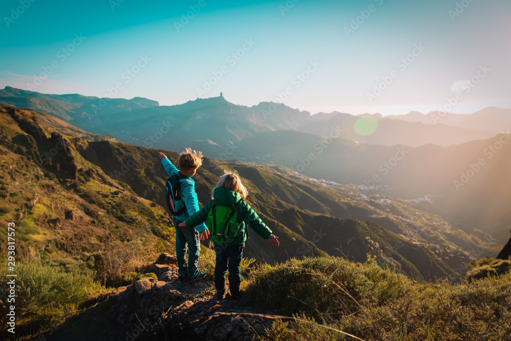 happy boy and girl travel in mountains at sunset