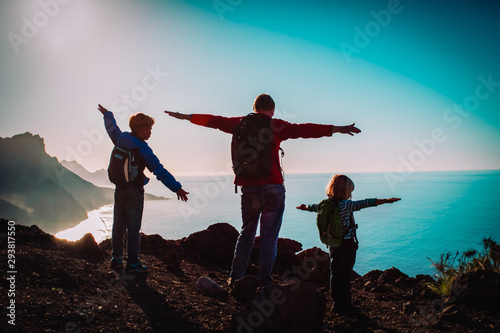 father with kids-boy and girl- enjoy travel in sunset mountains