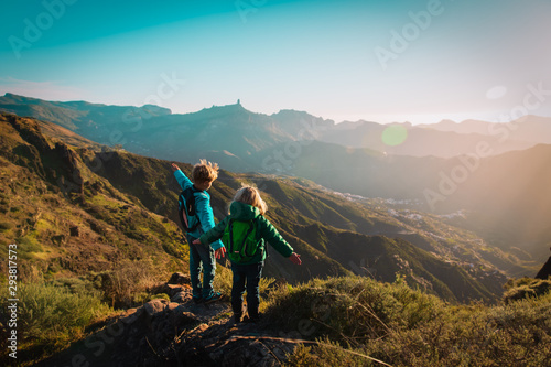 happy boy and girl travel in mountains at sunset