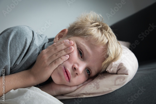 Sick child with fever at home, kid with toothache photo