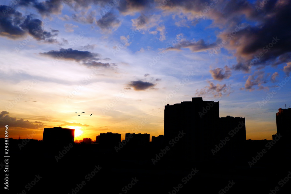 City skyline with buildings silhouettes in colorful sunset sky