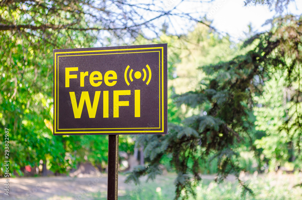 Free Wi-Fi signpost in yellow letters on black background in a park on the street