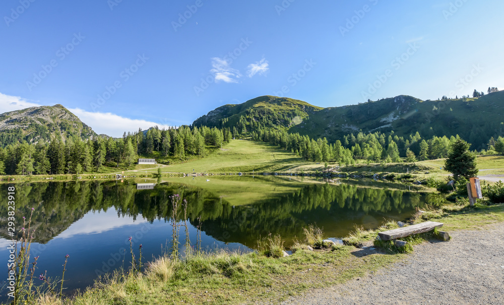 Wooden bench overlooking a bright clear lake. Wooden bench overlooking a bright clear lake.