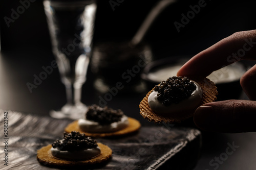 Sandwich with black caviar on black background
