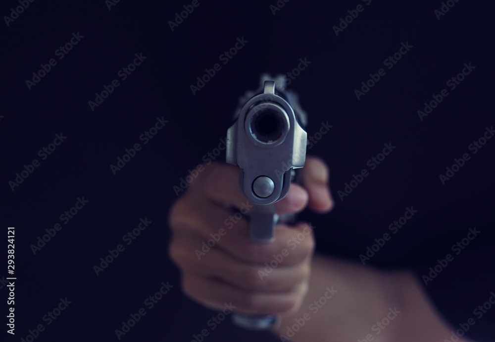 hand with gun on dark background. hand with gun on dark background.