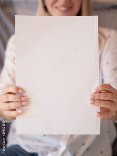 Close-up of a mock-up magazine held by a woman