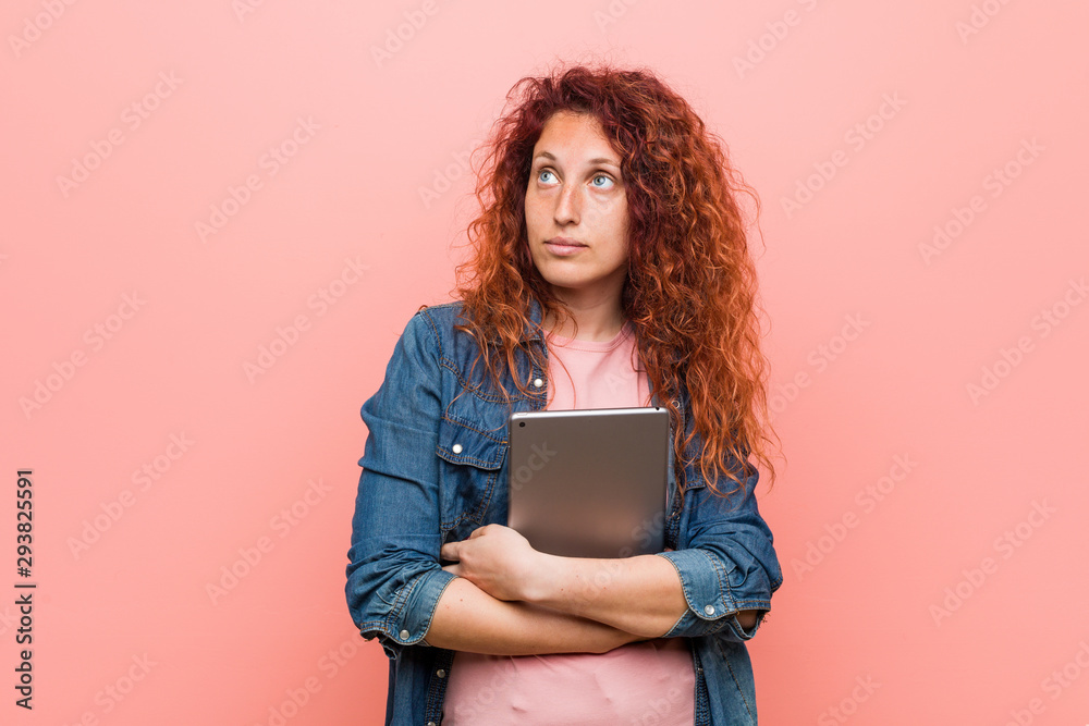 Young caucasian redhead woman holding a tablet smiling confident with crossed arms. Young caucasian redhead woman holding a tablet smiling confident with crossed arms.