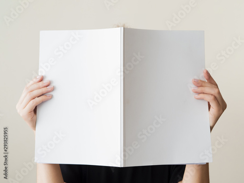 Mock-up magazine held by a woman photo