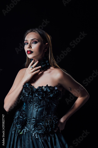 scary vampire girl in black gothic dress isolated on black